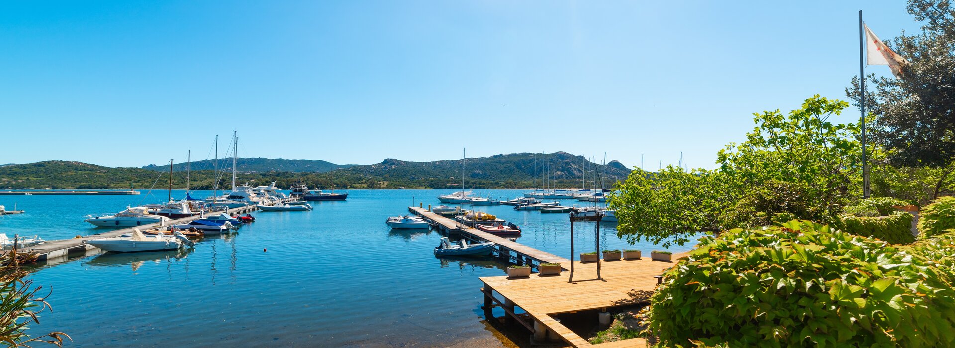Blick auf die hölzernen Bootsstege und Jachten im Hafen von Cannigione der ideale Startpunkt zum Gulet mieten Cannigione