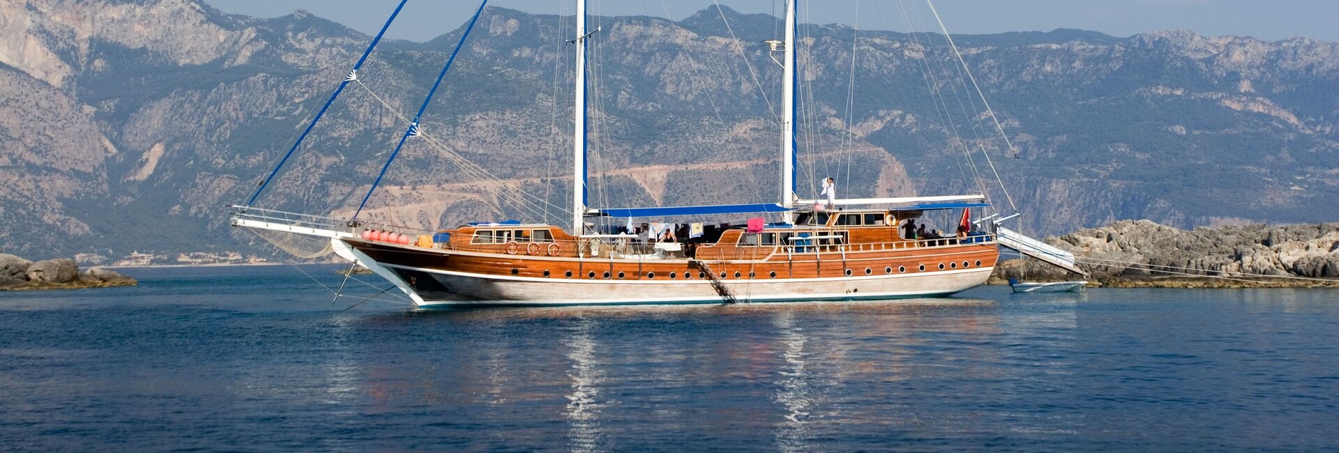 Eine klassische Holzgulet ankert vor einer imposanten Berglandschaft beim Gulet Charter Fethiye
