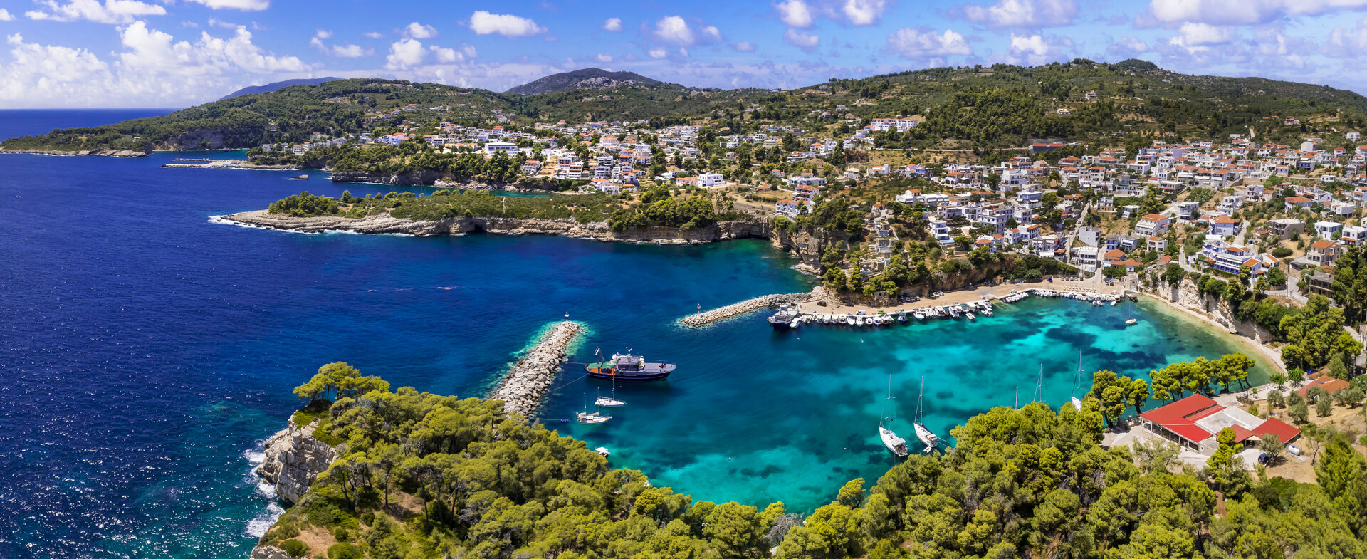 Вид с воздуха на бухту Вотси с лодками в бирюзовой воде, место для вашего круиза на гулете в Греции