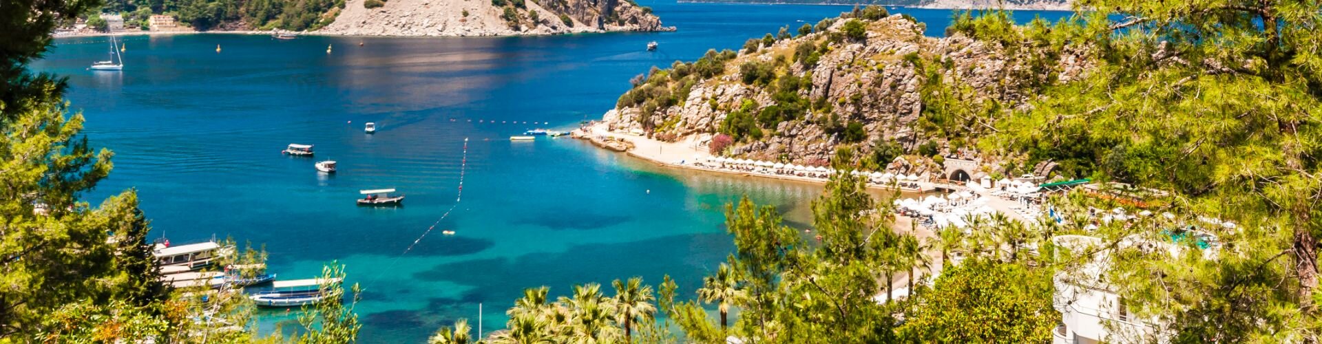 A gulet is anchored in a turquoise bay along the Turkish coast