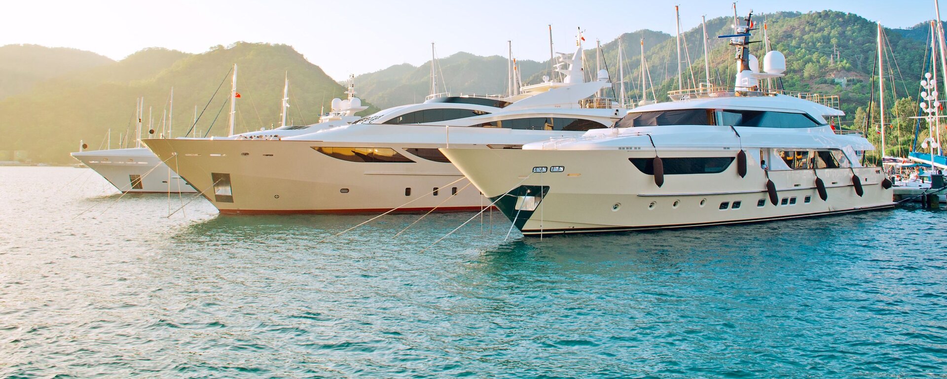 A fleet of luxury yachts moored in the harbour, perfect for a Motor Yacht charter Bodrum at sunset