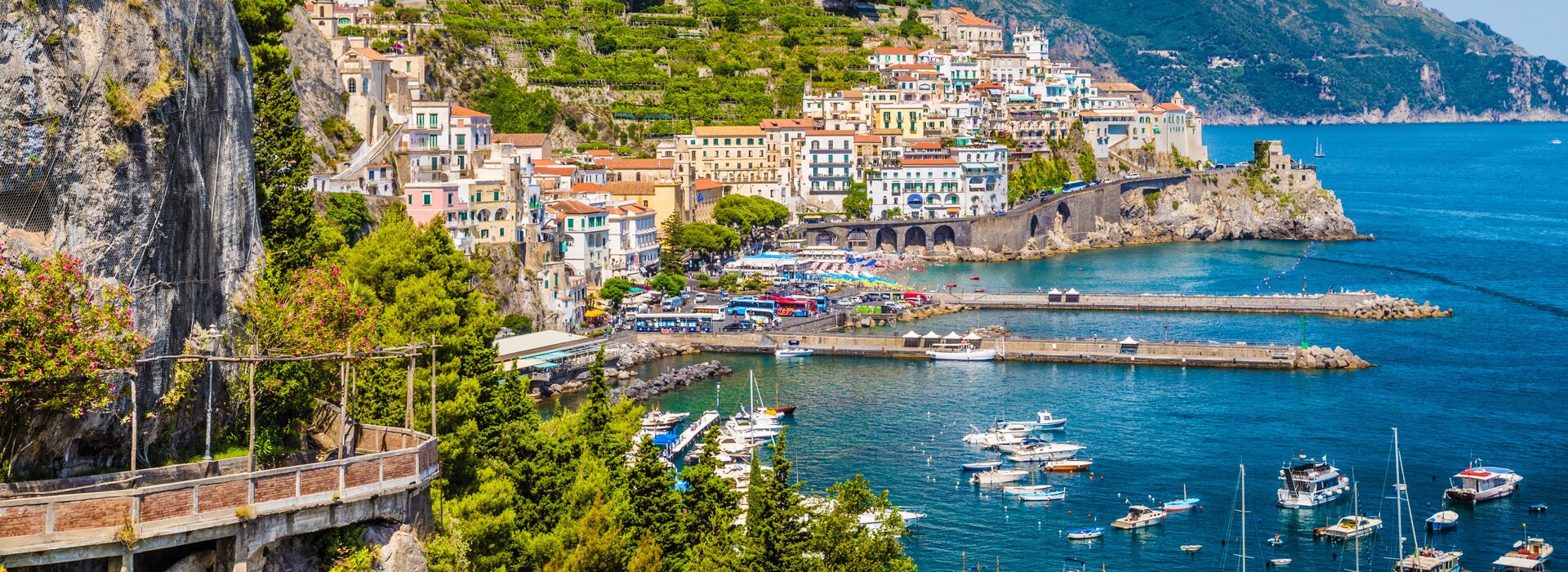 Panorama von Amalfi mit bunten Häusern und Booten im Hafen wo Motorboote in Italien gemieten werden