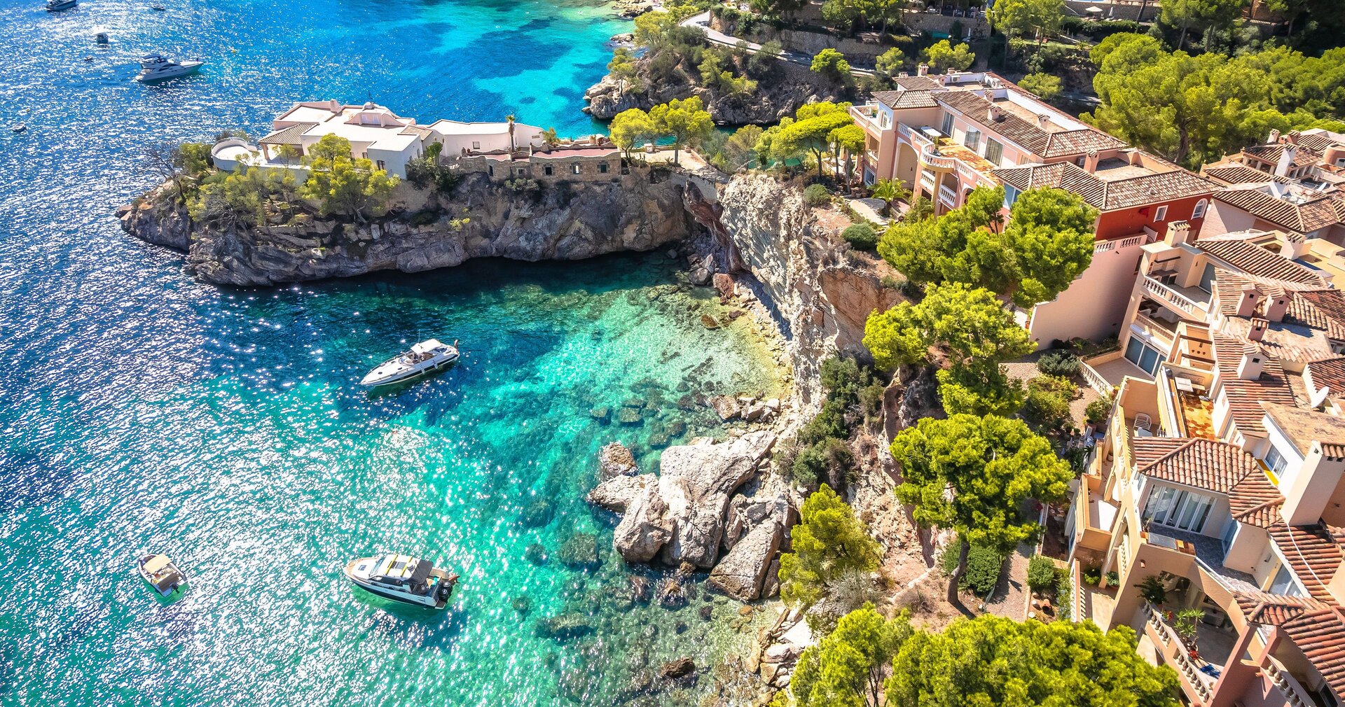 Eine exklusive Mittelmeerbucht mit luxuriösen Villen und Yachten bietet die ideale Basis für Motoryacht Charter Spanien