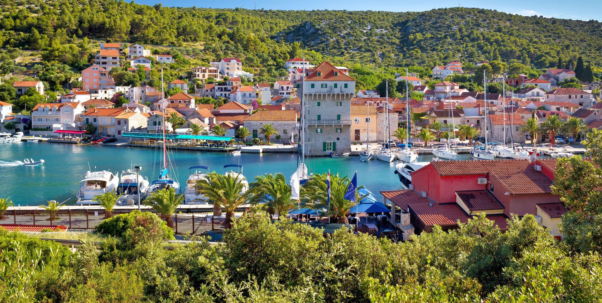 Марина Трогира с яхтами на фоне холмов, точка маршрута аренды моторных яхт в Хорватии