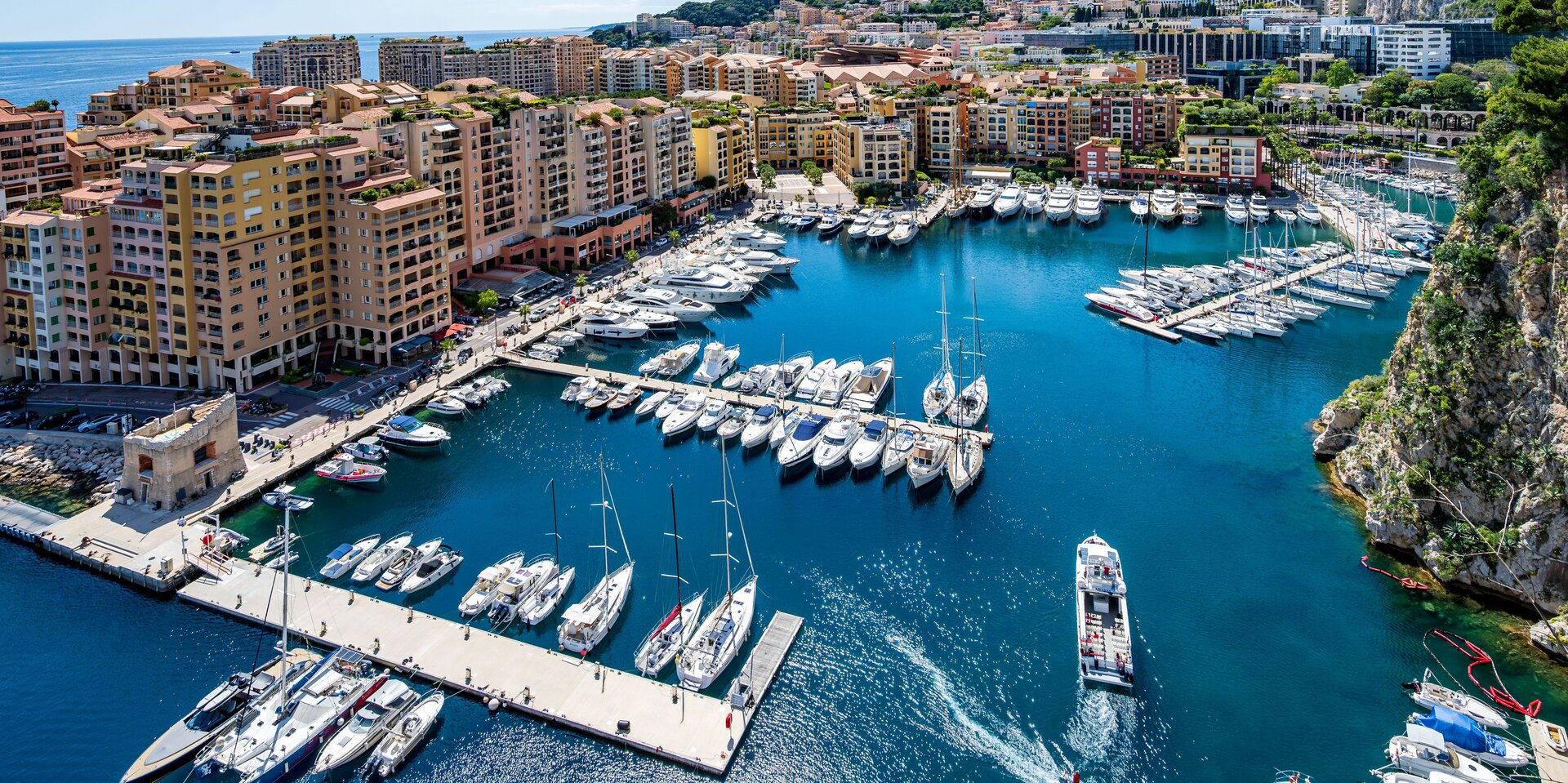 Alt-Text: Luftaufnahme vom Port de Fontvieille in Monaco mit Motoryachten an den Stegen