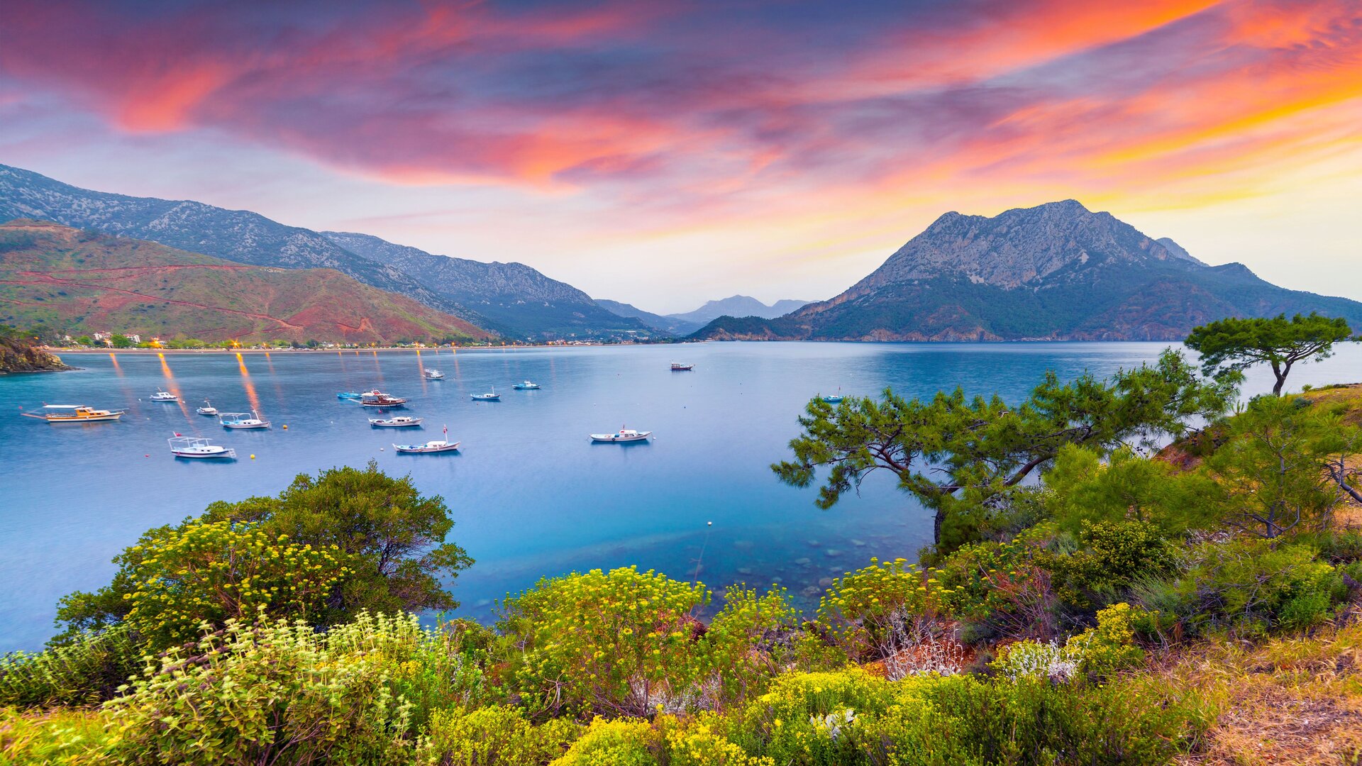 Вид на бухту Гечека с традиционными судами и арендой моторсейлера на фоне красочного заката