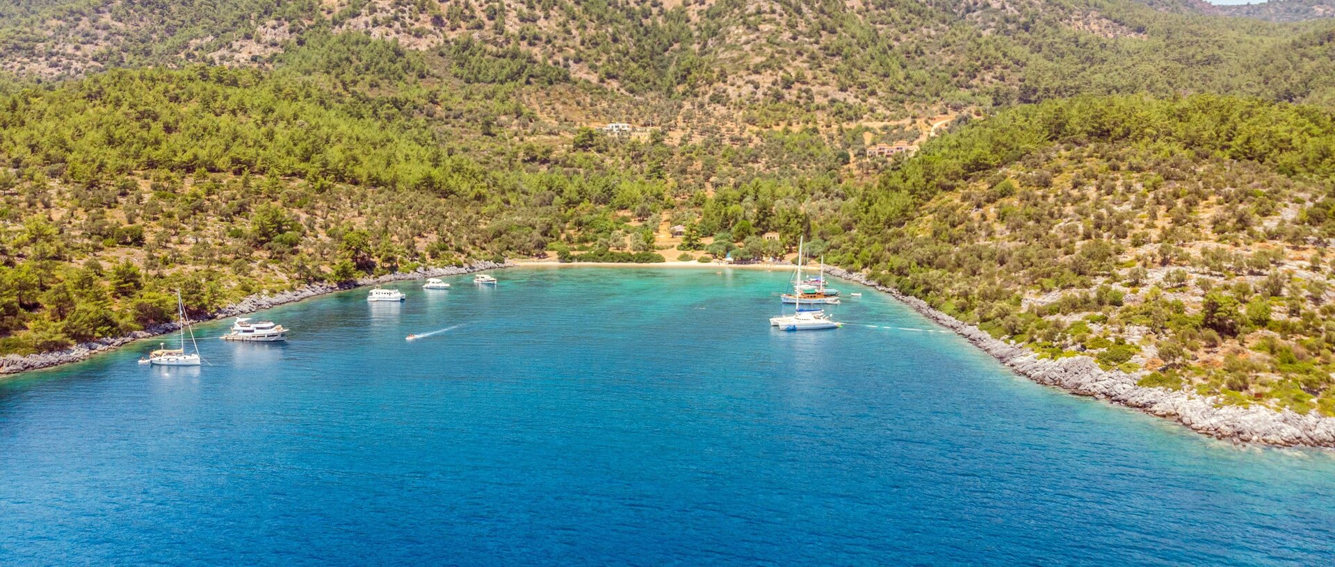 Several yachts anchored in a turquoise bay for a sailing yacht charter in Fethiye