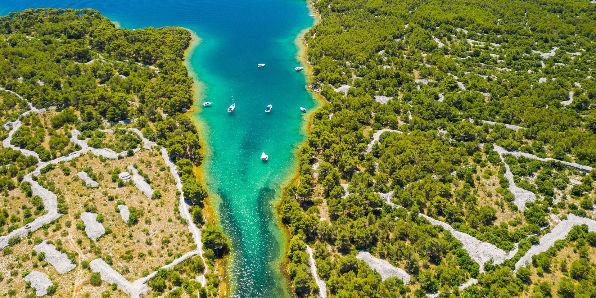 Mehrere Yachten beim Segelyacht Charter Sibenik auf dem Weg durch den Kanal vorbei an der Festung St. Nikolaus