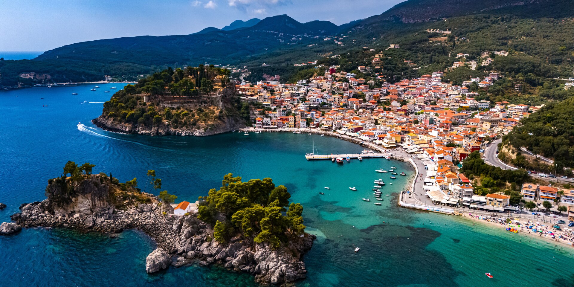 Buntes Küstenpanorama von Parga mit Pinieninseln und türkisblauem Meer, ideal für einen Yachtcharter Preveza