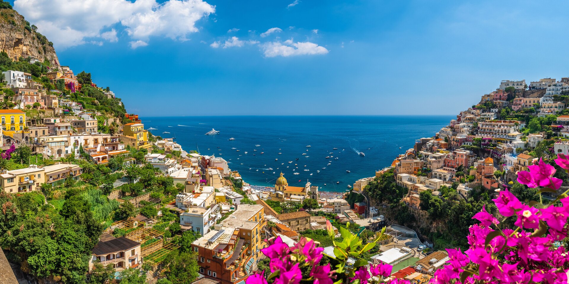 Positano mit goldener Kirchenkuppel und Yachten in der Bucht, ideal für einen Yachtcharter Salerno