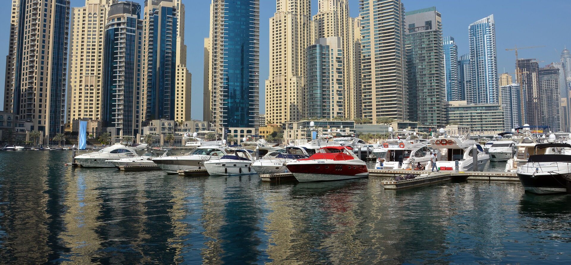 Gökdelenlerin önünde sıralanmış tekneler ile lüks bir yat kiralama Dubai deneyimi yaşayın