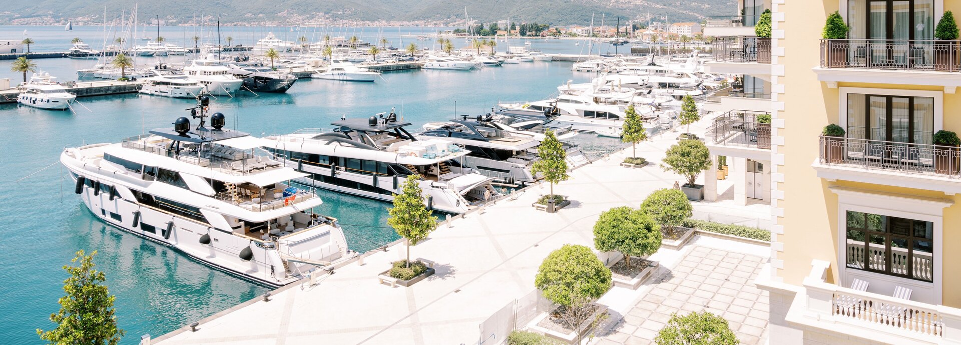 Luxusyachten liegen an der sonnigen Promenade von Porto Montenegro, ideal, um ein exklusives Boot mieten Montenegro