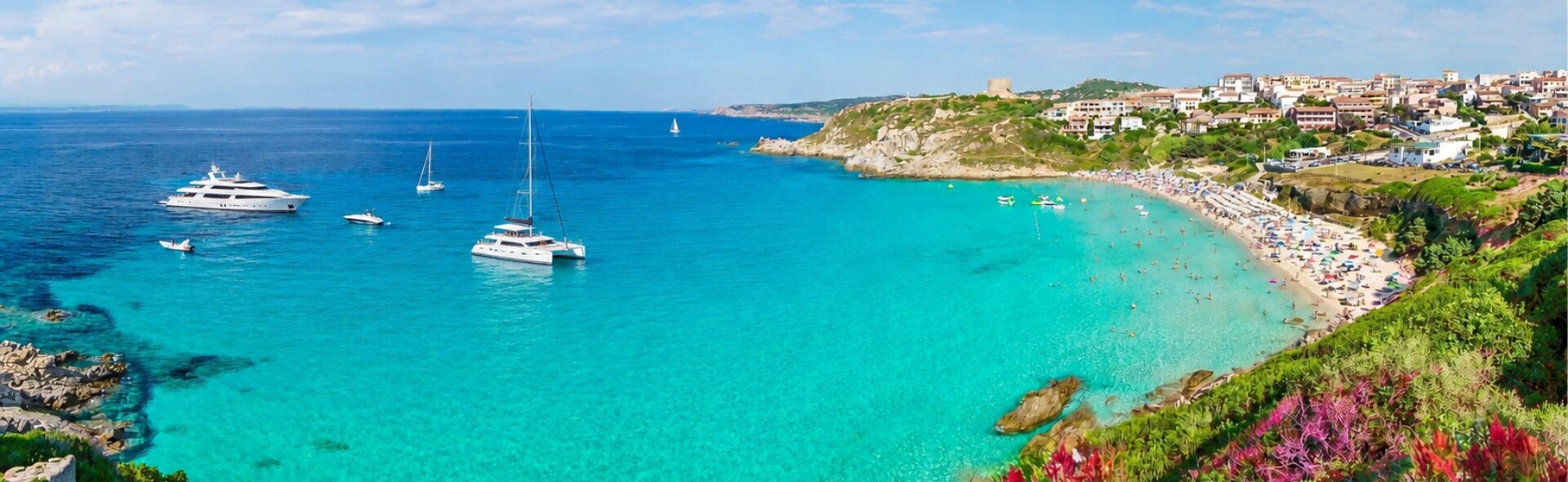 Motor yachts, catamarans and sailing boats are anchored in a turquoise bay along the Sardinian coastline.